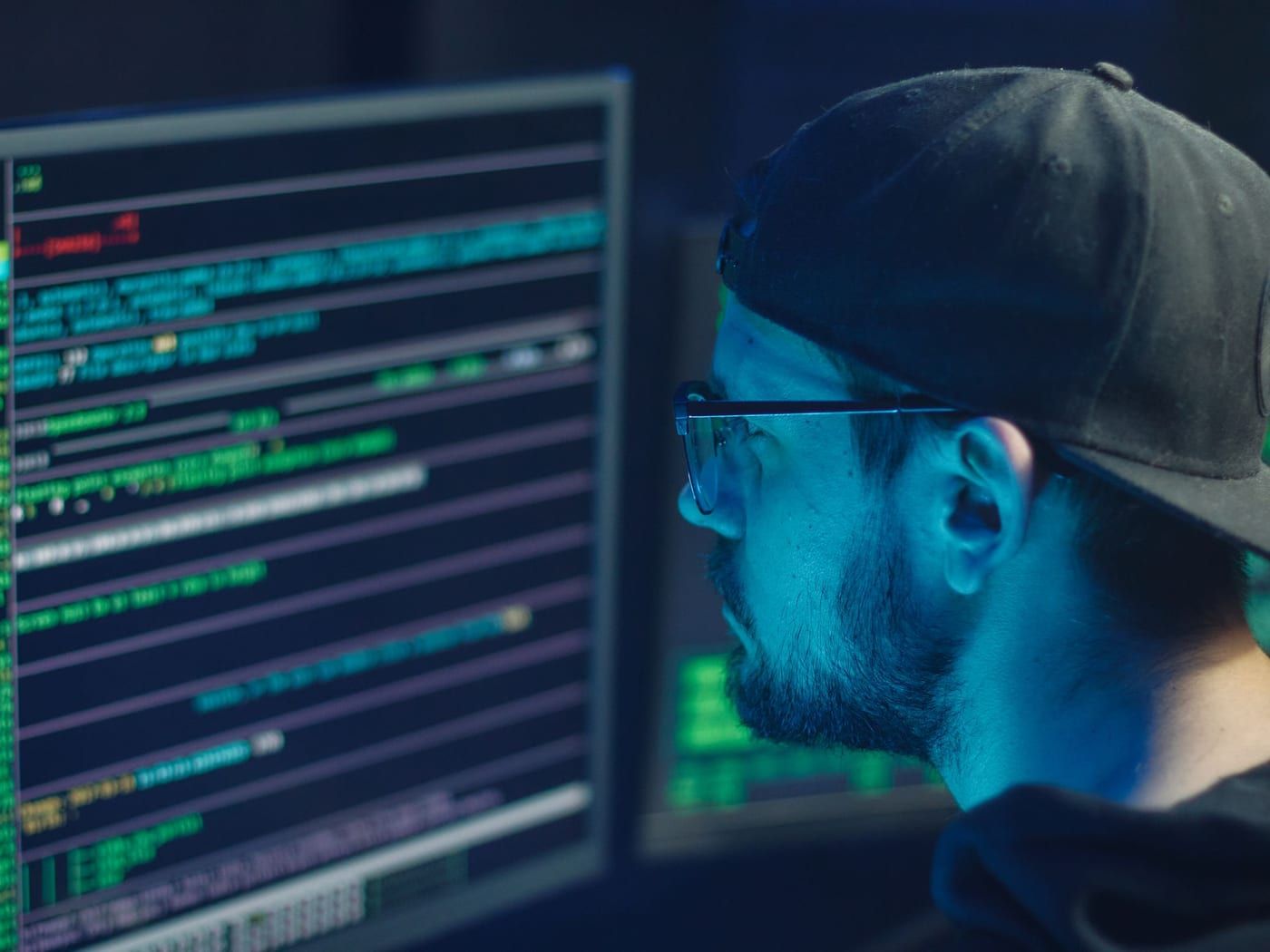 Bildschirme mit Systemprotokollen in einem abgedunkelten Arbeitsraum